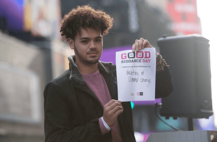 Van Troy Ulloa is holding up a sign that reads "Good riddance to doubting climate change."