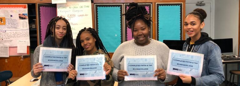 Four students hold up signs that say "I completed FAFSA and TAP."