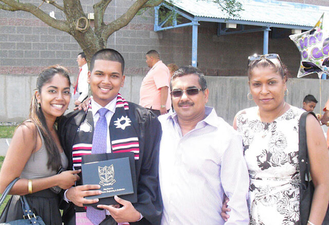 Stephanie poses for a picture with her family. Her brother is holding up his high school diploma.