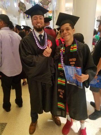 Javier is wearing a graduation cap and gown. He and his college advisor are shaking hands and smiling.
