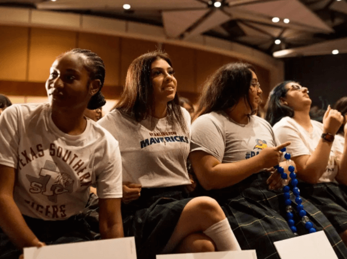 Young Women's Leadership Academy seniors wear college T-shirts at their signing day celebration.
