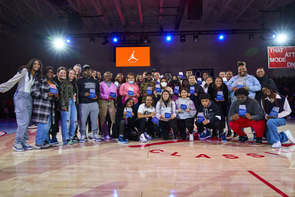 The Class of 2026 Jordan Wings Scholars pose for a large group shot on the basketball court.