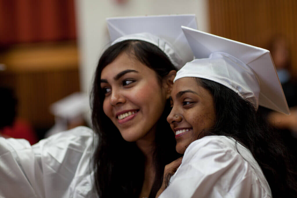 Janna and her friend are taking a selfie on their graduation day.