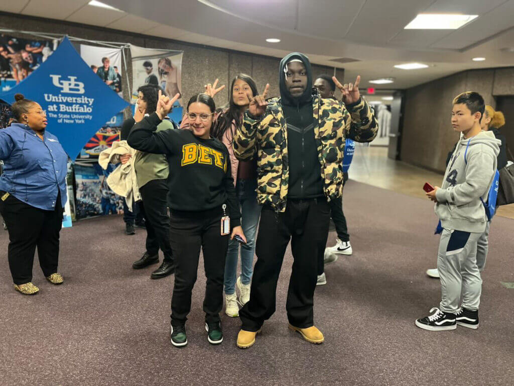 Maria and her student give the University of Buffalo bull horns hand gesture.