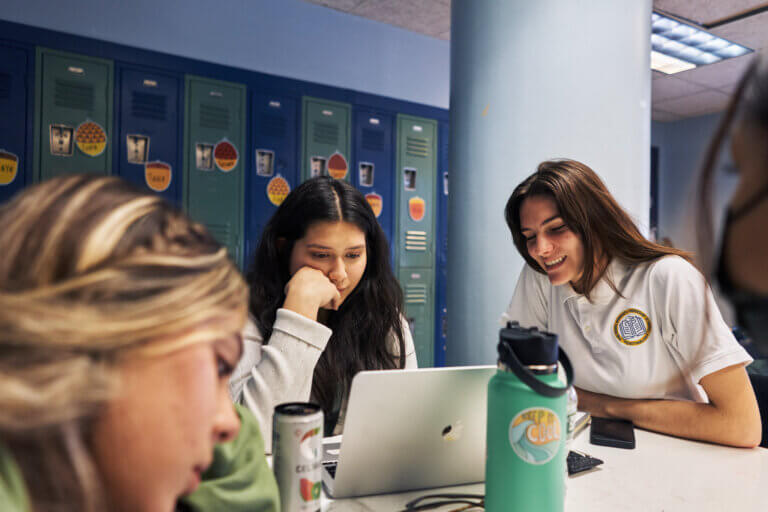 TYWLS students work together around a laptop