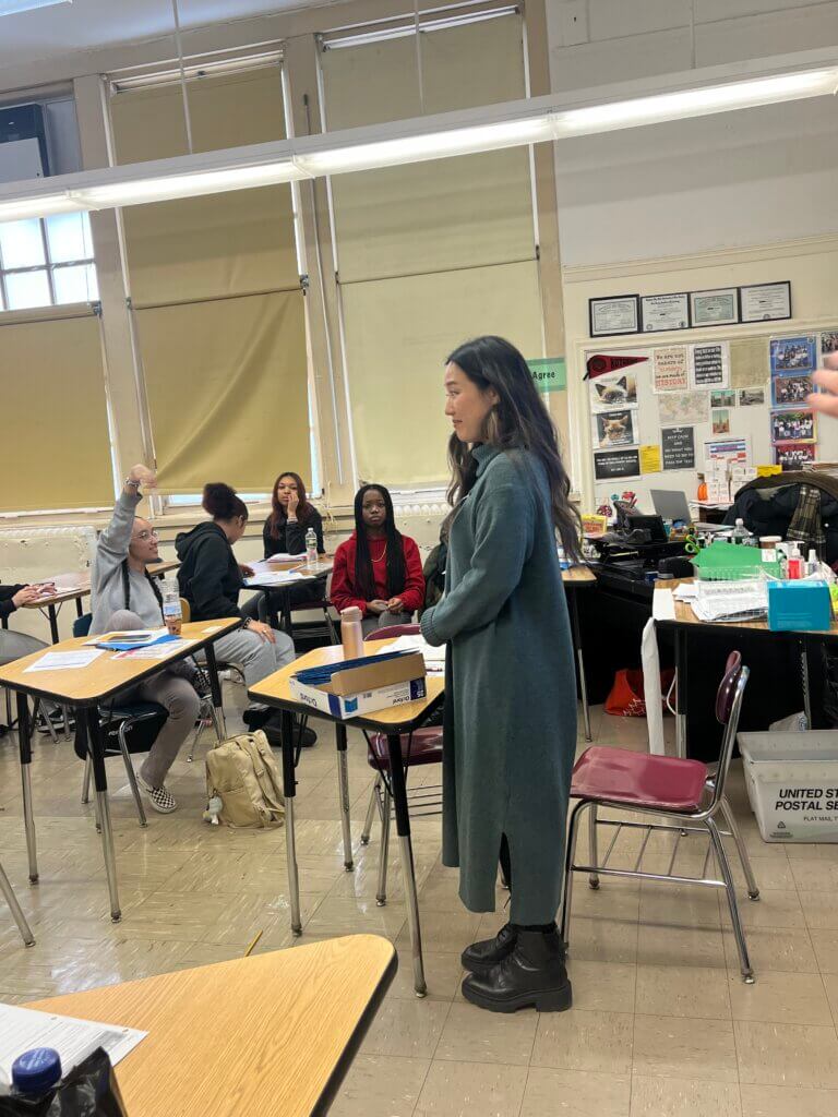 Volunteer takes questions from students about her work.