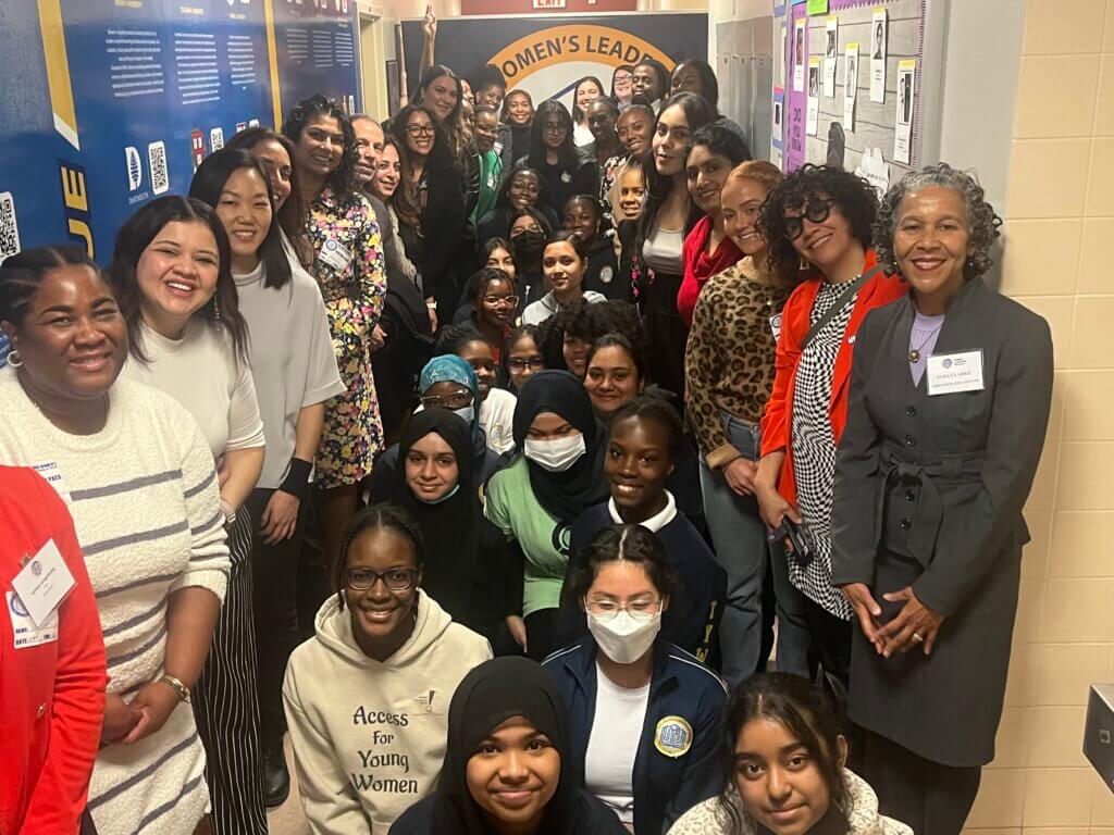 A group of students and volunteers pose together at TYWLS Queens.