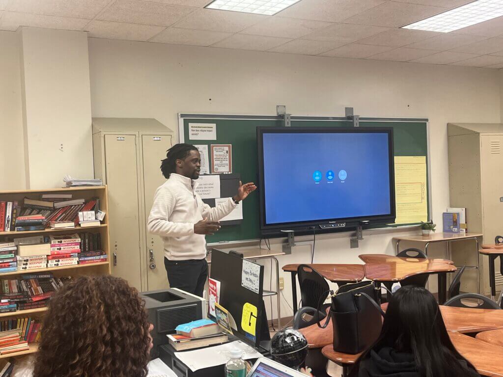 An employee from AMEX speaks to students about his work.