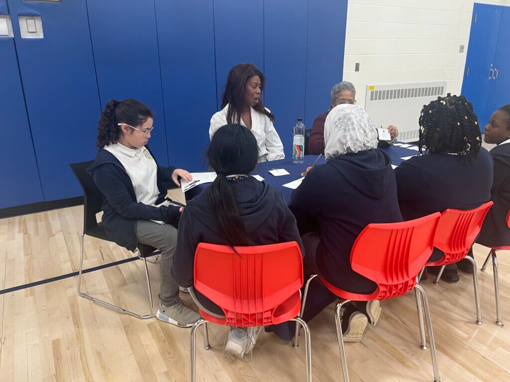 Students and volunteers have a thoughtful discussion.