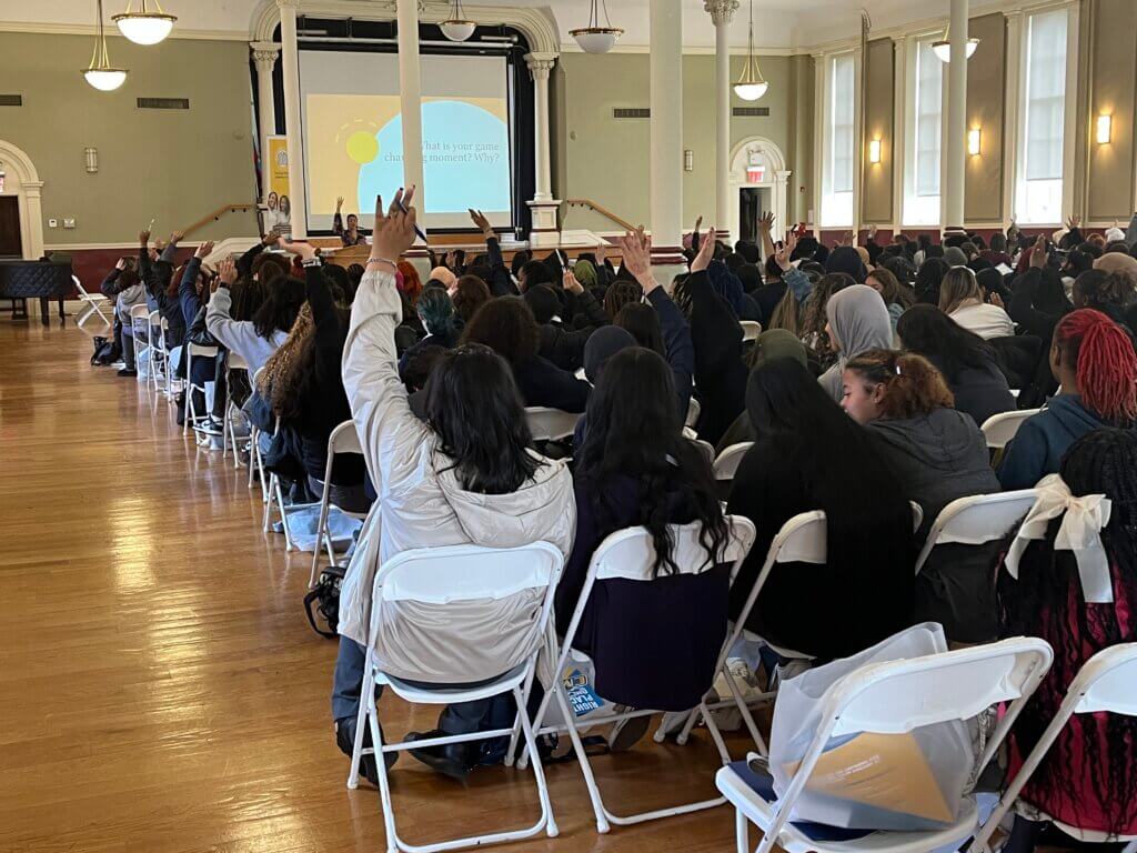Students raise their hands to share out their personal "game-changing moments"