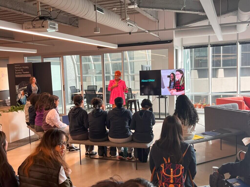 Students watch a presentation welcoming them to EPAM