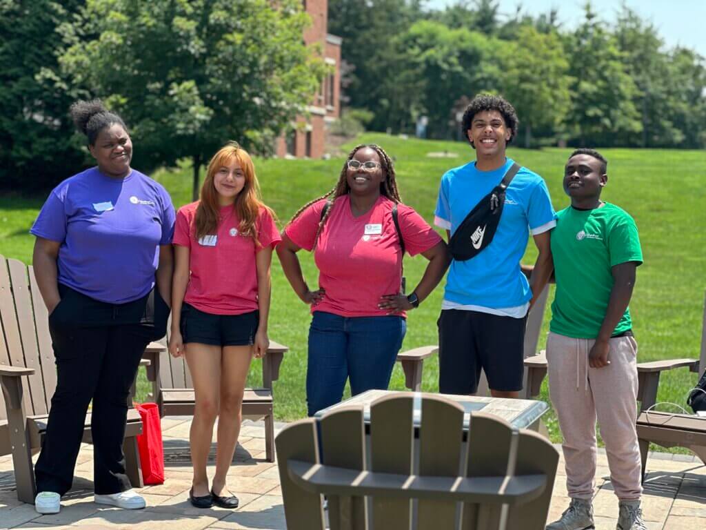 A director of college counseling with her 4 students on a college campus