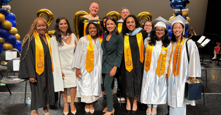 Allison Persad, Principal of The Young Women's Leadership School of Astoria, celebrates graduation with a group of students and guest speaker Alexandria Ocasio-Cortez
