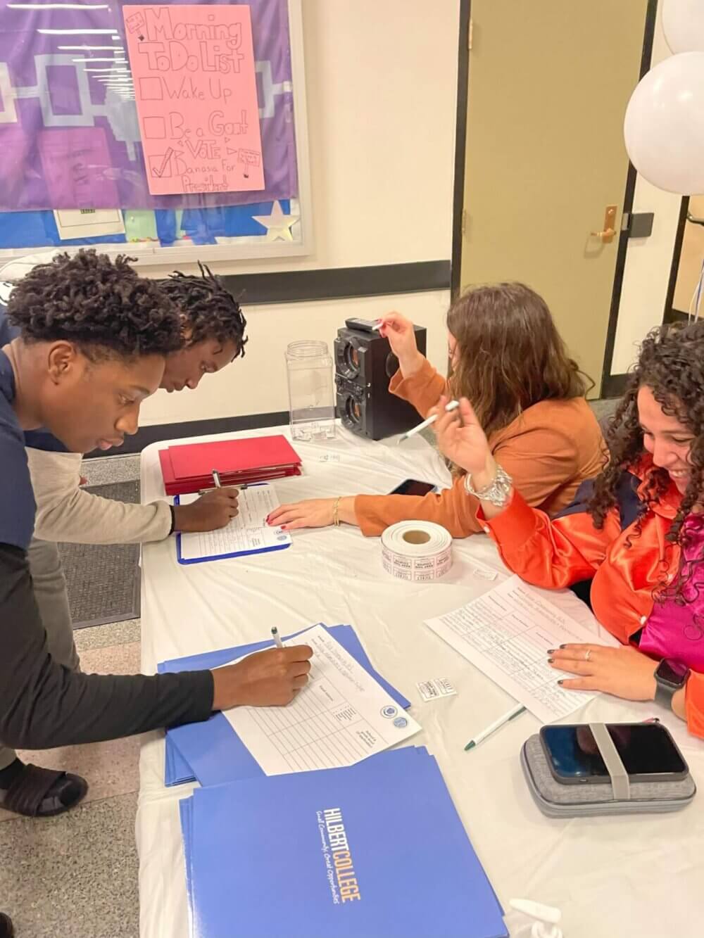 Students sign up for more information at a college table during their school's college fair