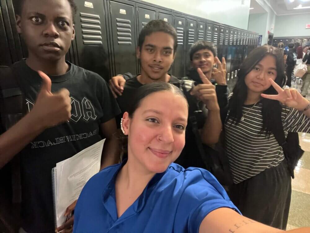 Four students give thumbs up sign with Director of College Counseling Maria Lascarro