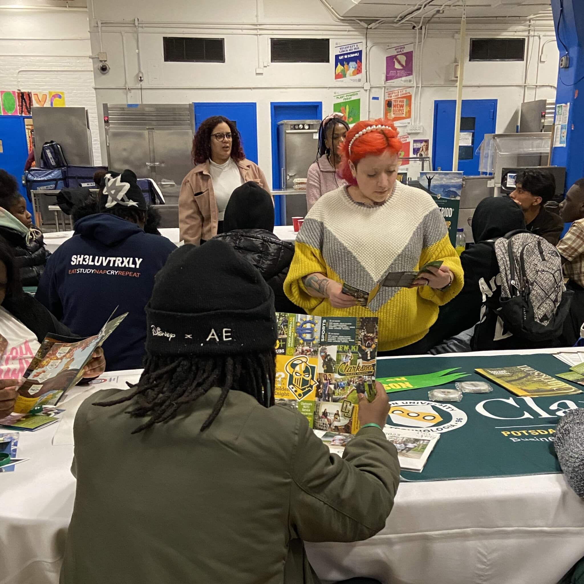 College HEOP staff talks with high school students at a table