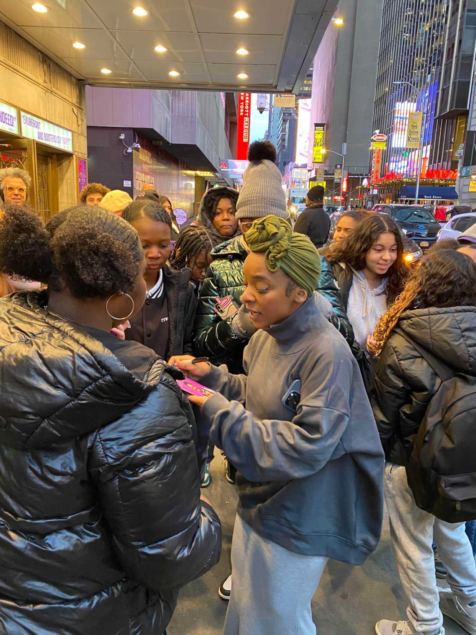 Actor Kara Young signs autographs for students outside theater