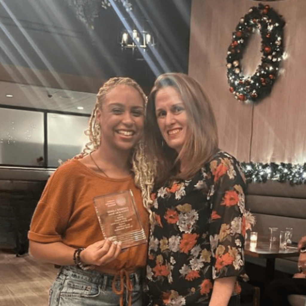 Teacher Ms. Lahoz holds an award, with Principal Eisenberg of TYWLS Bronx