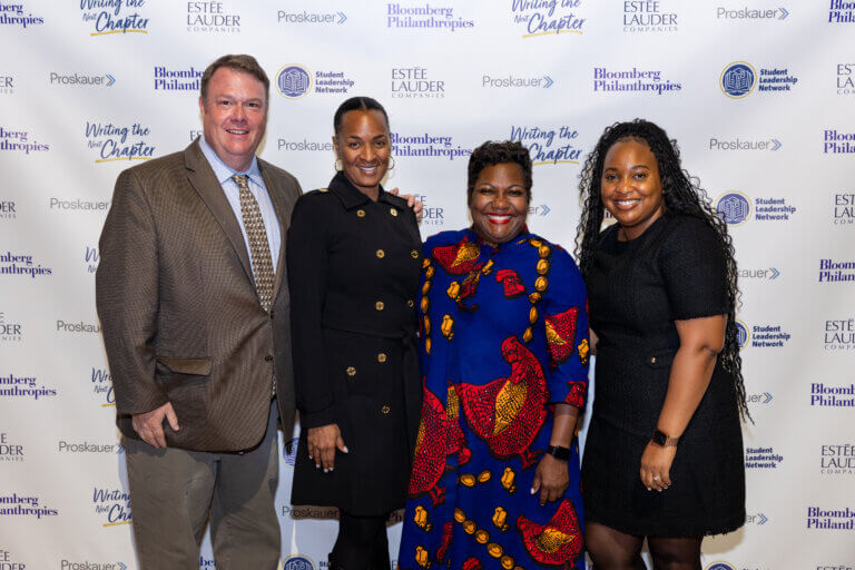 Four educators and leaders from Student Leadership Network and Ivy Prep Academy pose for photo in front of event backdrop