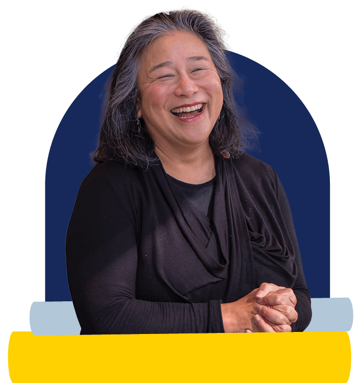 Figure of Tina Tchen smiling with hands clasped in front of her