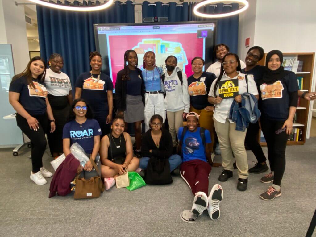 Alumni and staff wearing college t-shirts gather for group photo