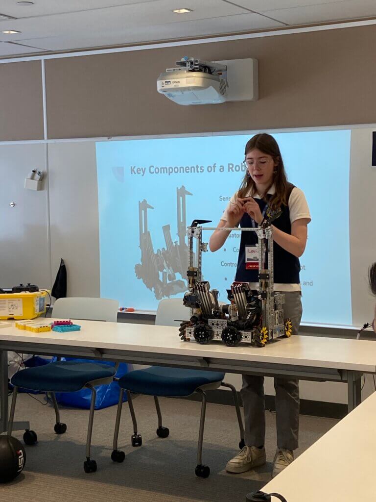 Student points out different components of a robotics machine