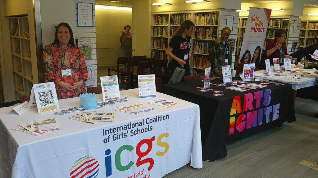 People stand by tables in a library, tables have nonprofit organizations' signage