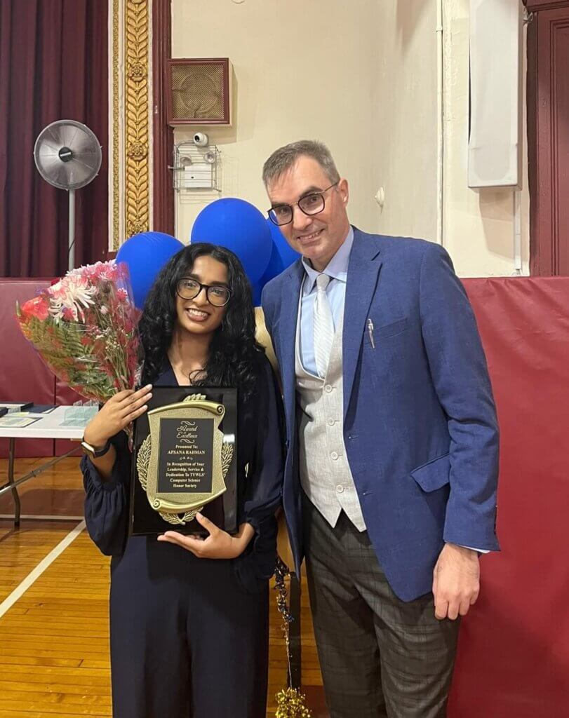 Alumna Afsana holding Computer Science Honor Society award plaque with her teacher Andy Jordan