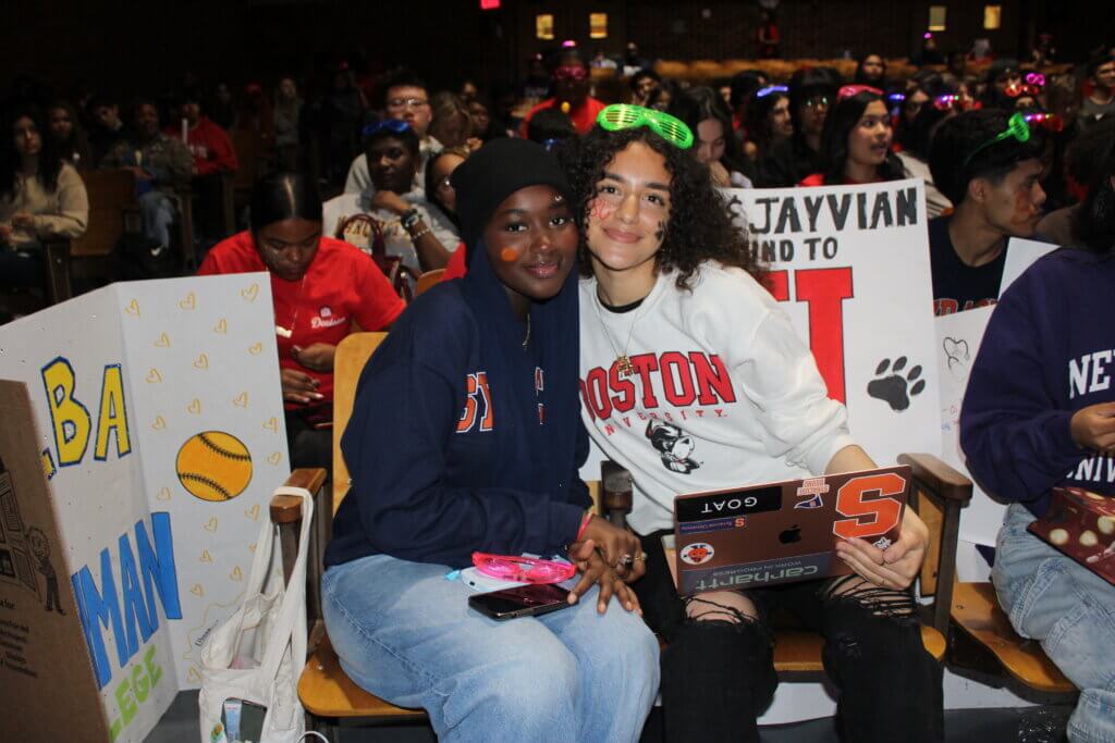 two students wearing Syracuse and Boston University sweatshirts smile for photo