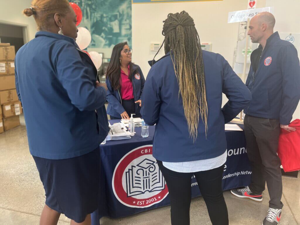Staff gather around a sign-in table at the college fair