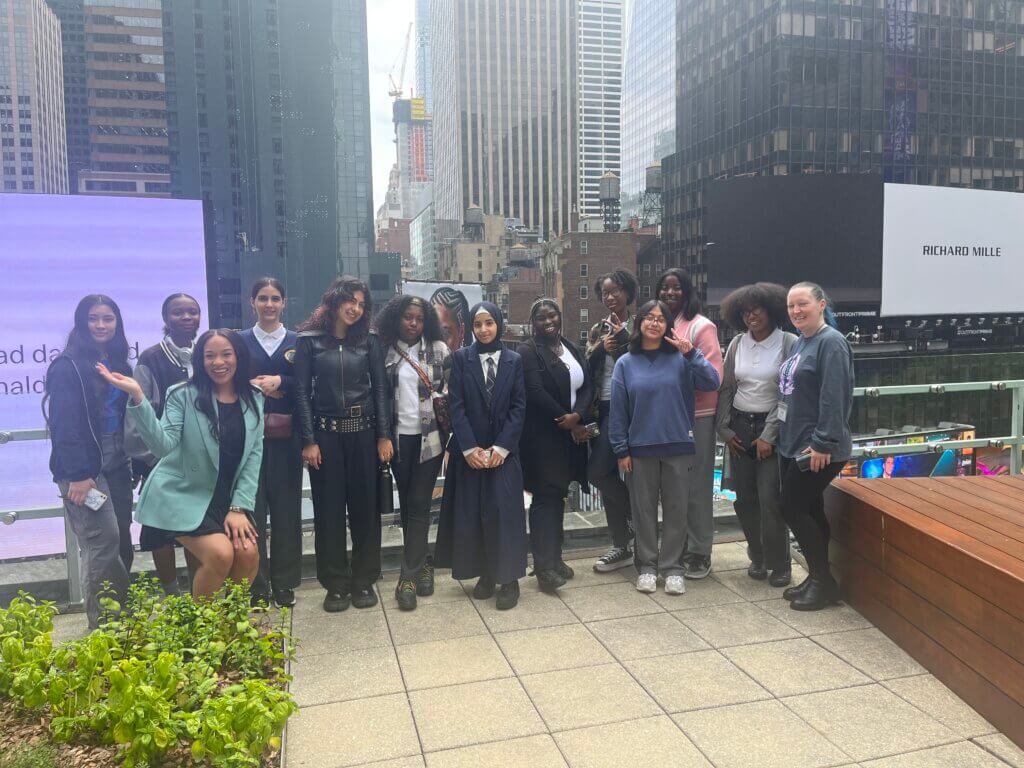 Students and BET employees pose for photo on a rooftop garden overlooking midtown Manhattan