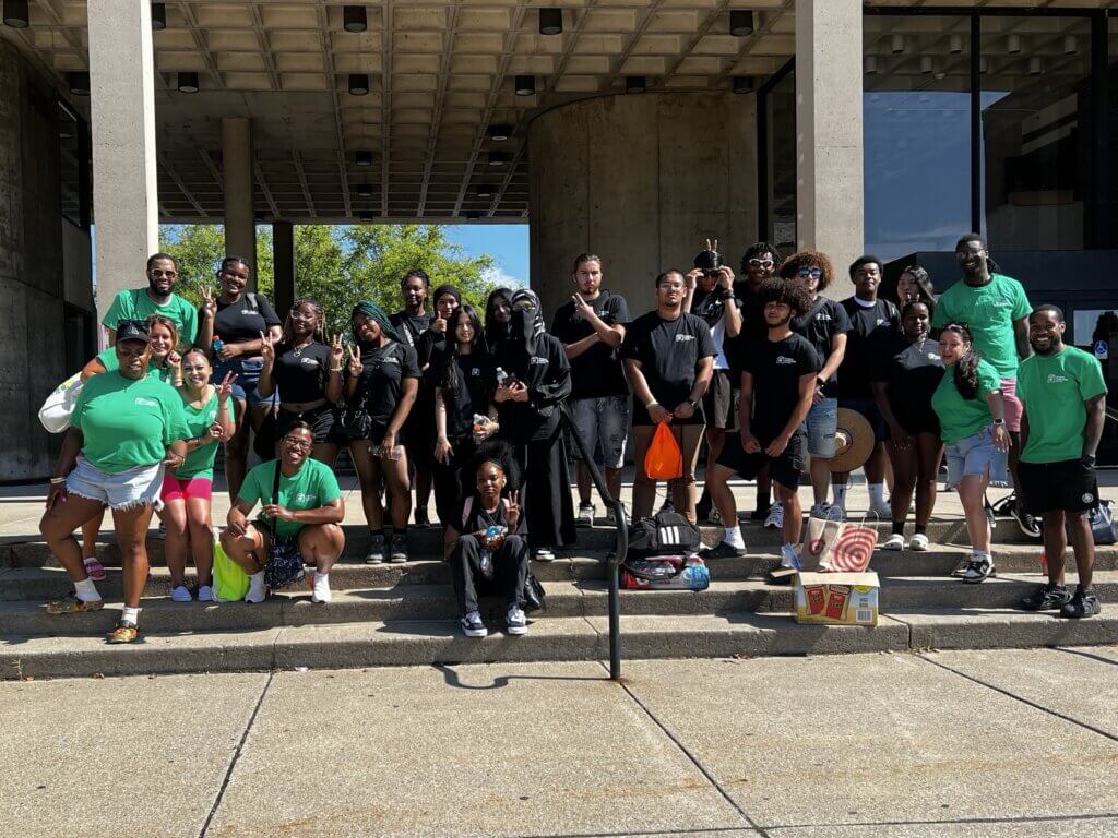 Students and staff pose for a photo outside a Buffalo State University campus building