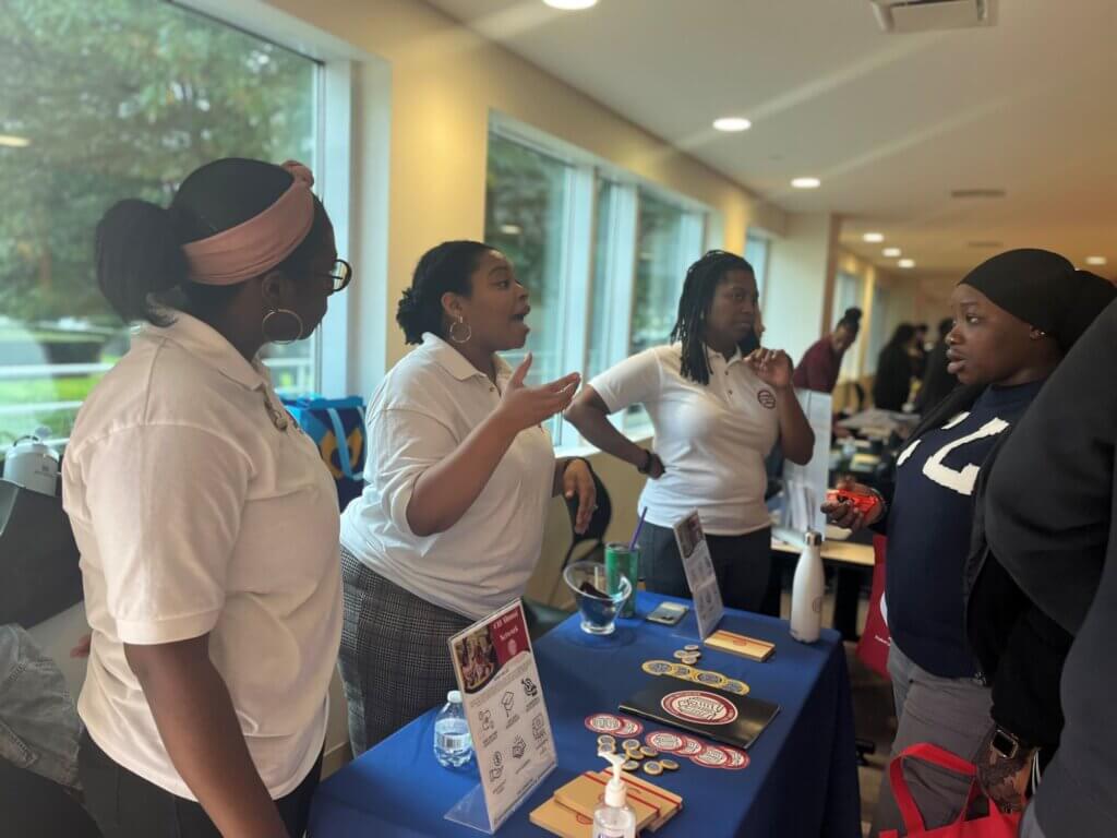 Student Leadership Network staff talk with a student about programs to support the college journey.