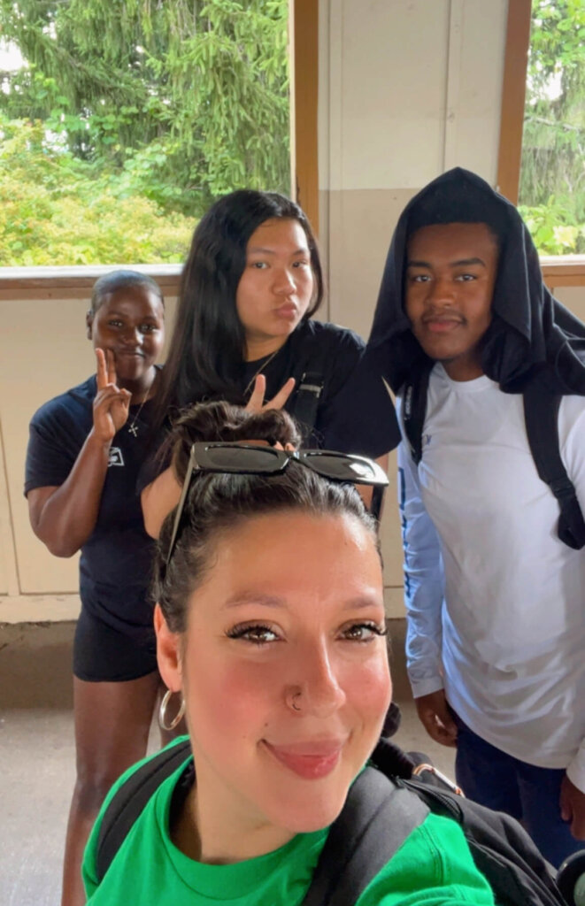 College counselor takes a selfie photo with three students