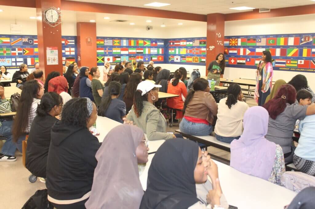 School principal and director of college counseling welcome families to Senior Family Night in cafeteria