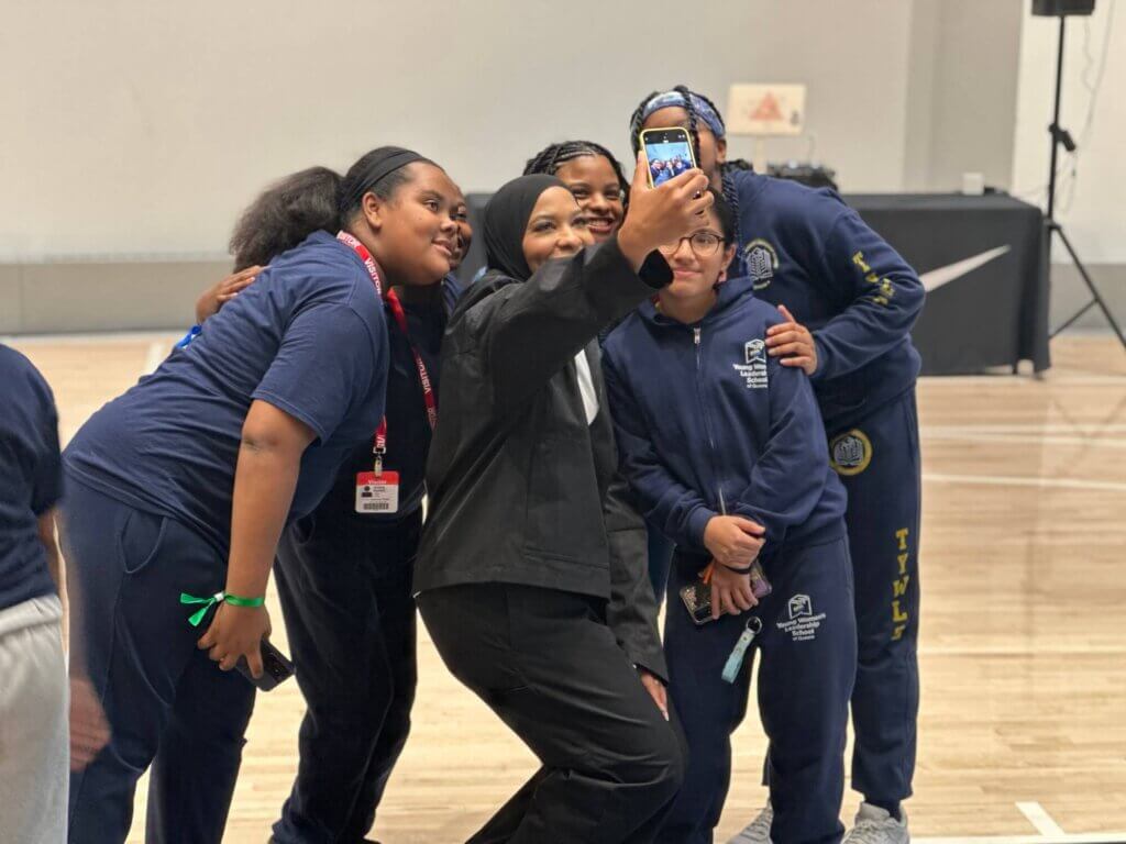 Decorated athlete activist Ibtihaj Muhammad takes a selfie photo with group of female students