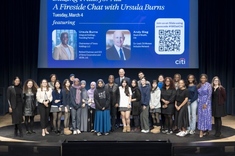 Students on stage with Ursula Burns pose for group photo