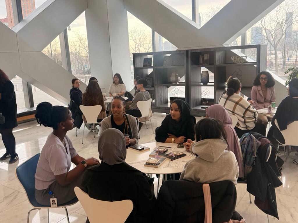 students and Citi employee are seated at a table to practice networking skills