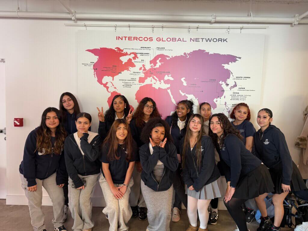 Students pose for photo in front of world map that shows Intercos' global network