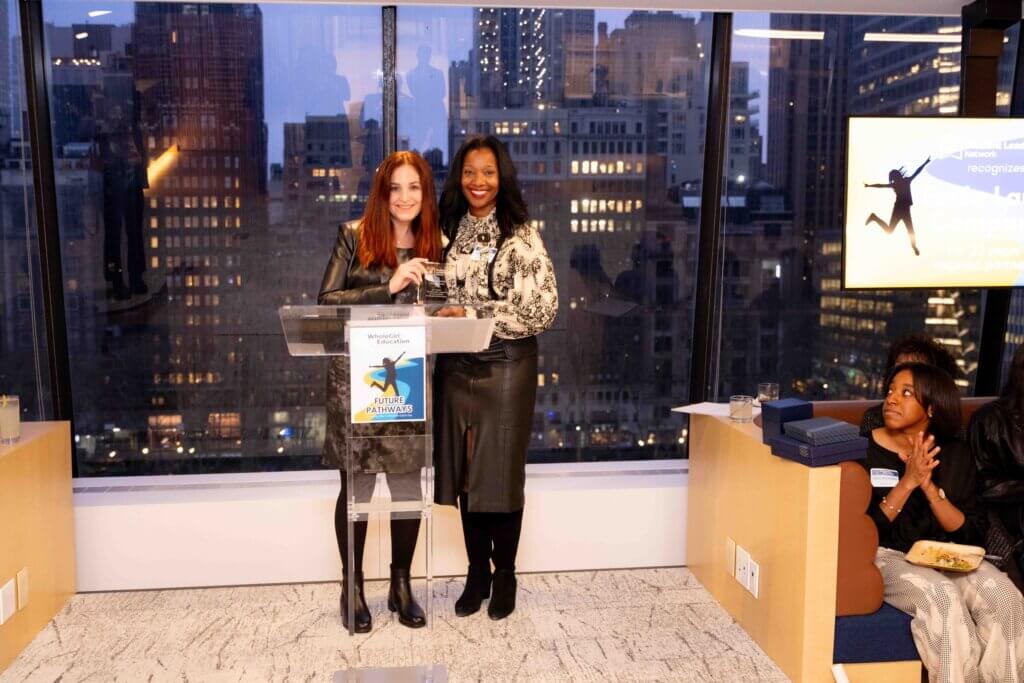 Lauren Traum receives a crystal plaque from Yolonda Marshall behind a podium