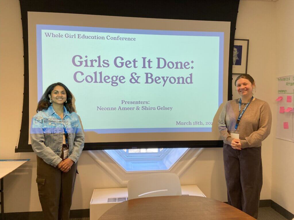 Educators stand in front of presentation slides