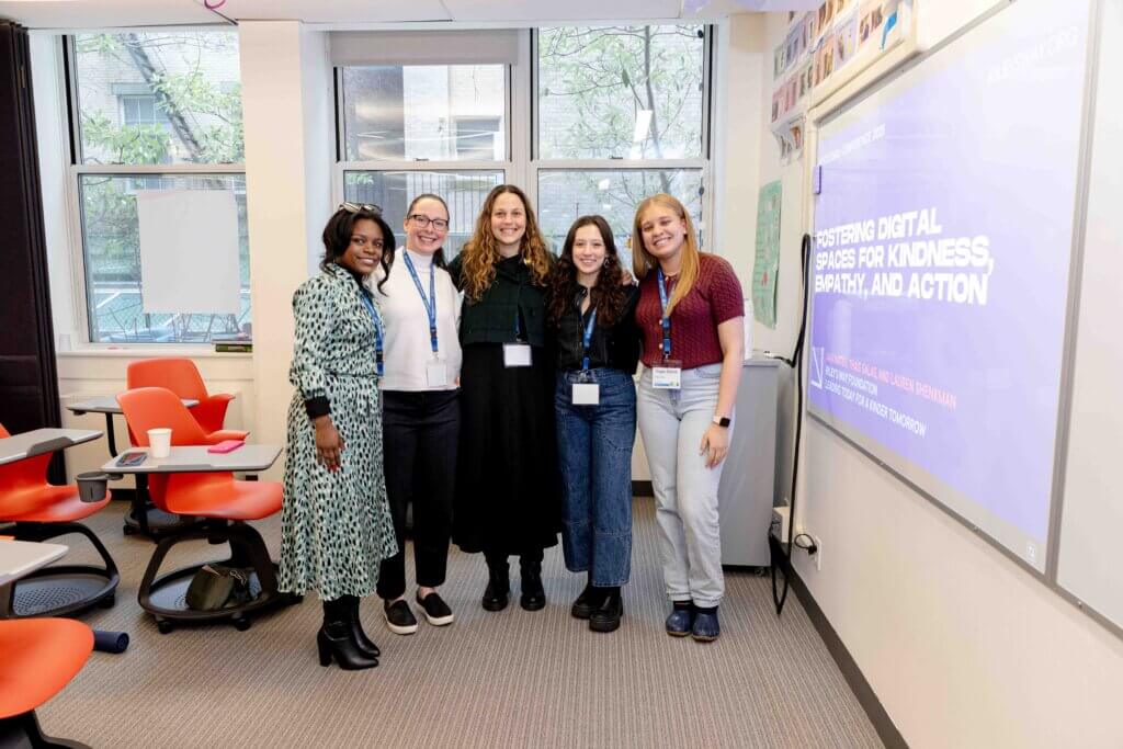 Educators stand in front of presentation slides