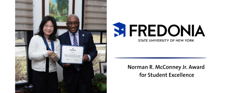 Female college students holds up medal next to male college dean who holds up a certificate