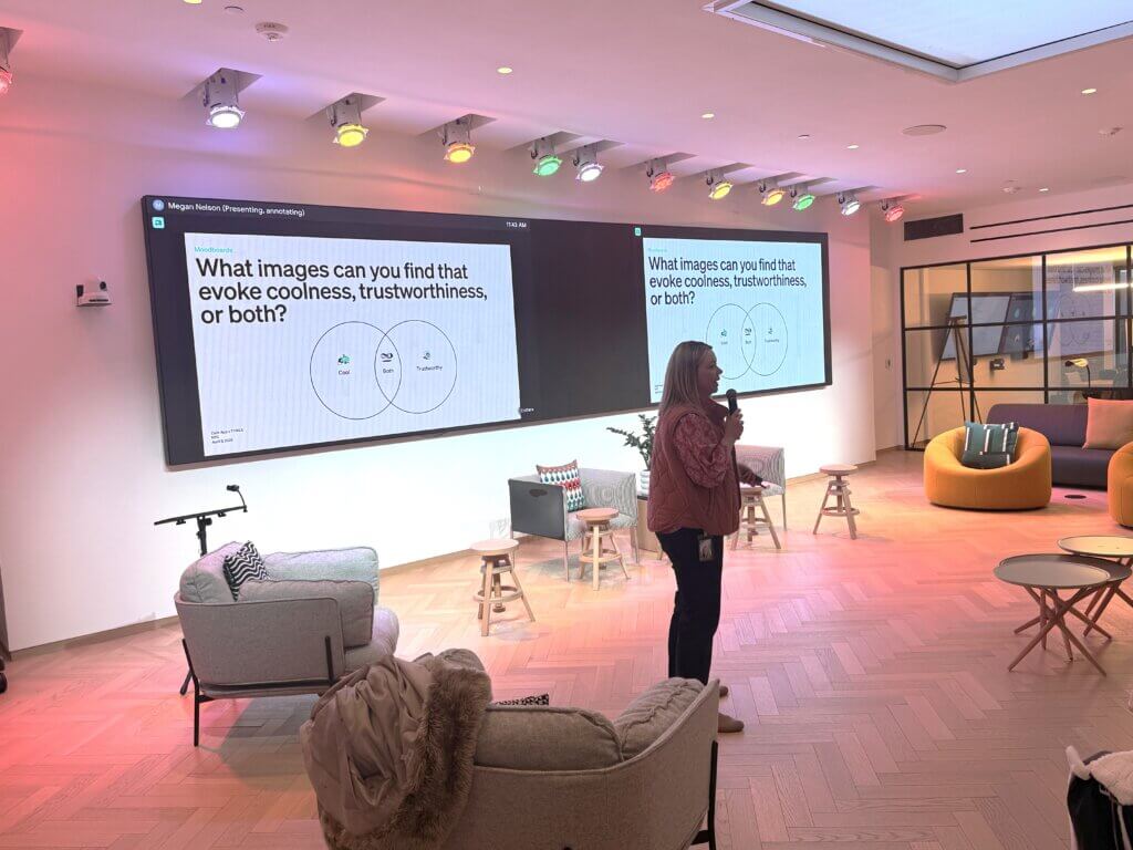 A person stands with a microphone in a modern lounge, presenting a slide that asks about images evoking coolness, trustworthiness, or both.