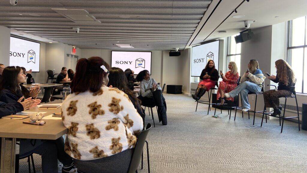 A panel of five women speaks to an audience seated at tables in a modern conference room, with Sony logos and the SUNY McConney EOP award highlighted on screens.