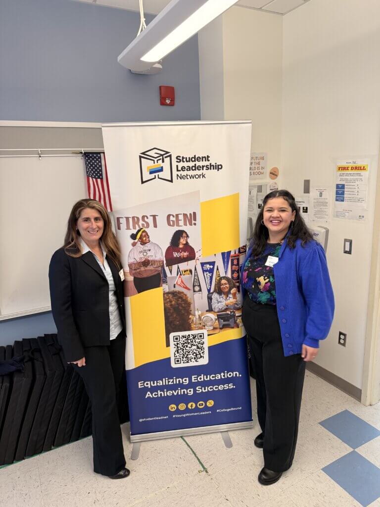 Two women stand beside a Student Leadership Network banner in a classroom, which highlights First Gen!, early career exposure, and the message Equalizing Education. Achieving Success.