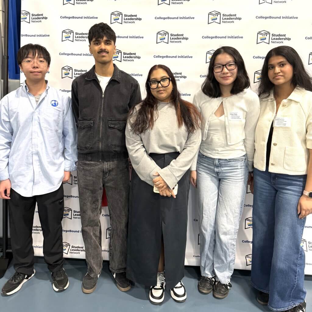Students smiling stand in front of a CollegeBound Initiative step-and-repeat banner